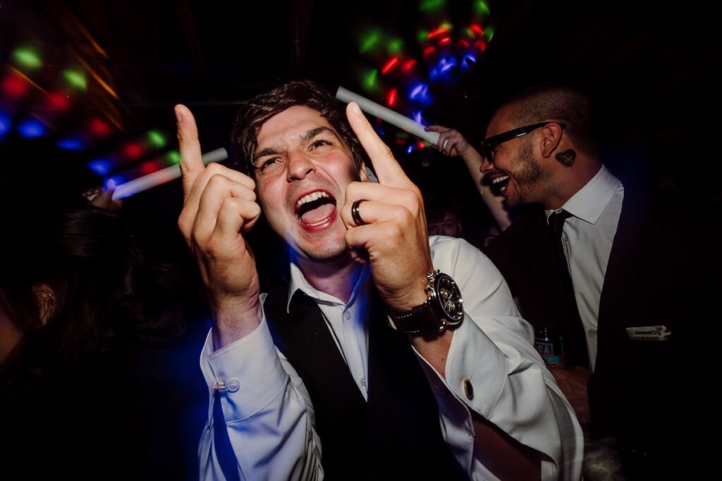 Groom DJing during reception at Sutton Barn.